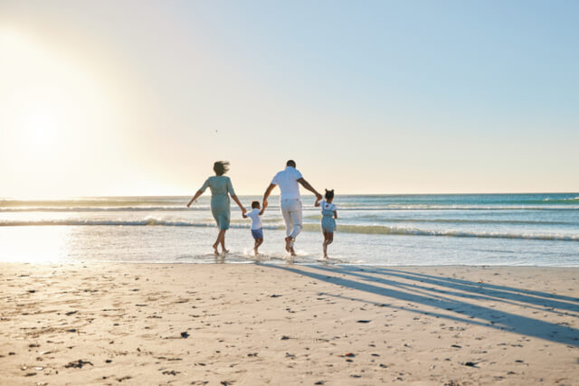 A family of four walking on the beach